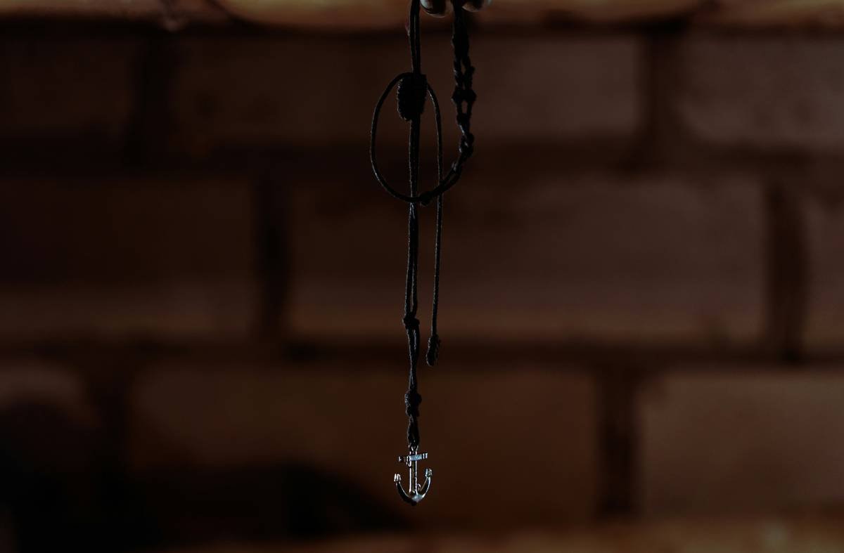 Side-by-side: left shows bare matte black hair spikes; right shows same spikes adorned with tiny silver chains, micro-studs, and asymmetrical metal cuffs. Realistic lighting, salon setting.